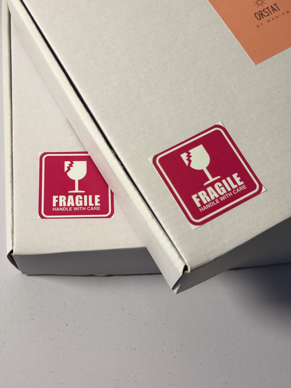 Fragile Handle With Care stickers by ORSTAT on a shipping box