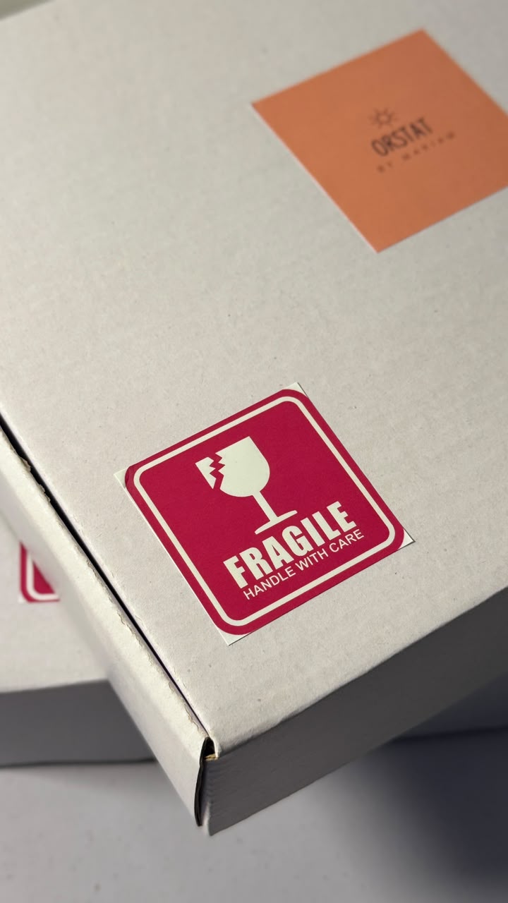 Fragile sticker close-up on box corner thumbnail